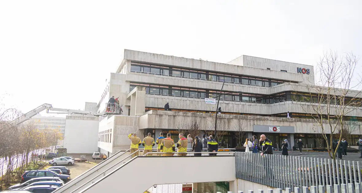 Demonstranten klimmen op het dak van NOS-gebouw - Foto 15