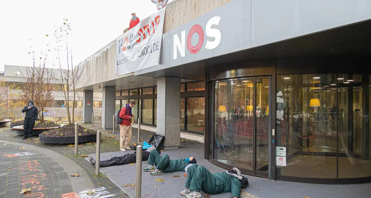 Demonstranten klimmen op het dak van NOS-gebouw - Foto 9