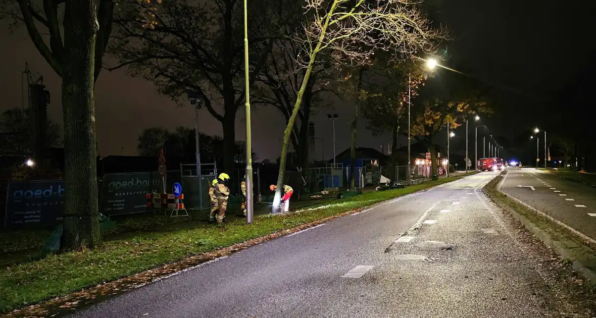 Brandweer zaagt over weg hangende boom om