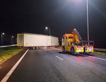 Vrachtwagentrailer waait om op snelweg