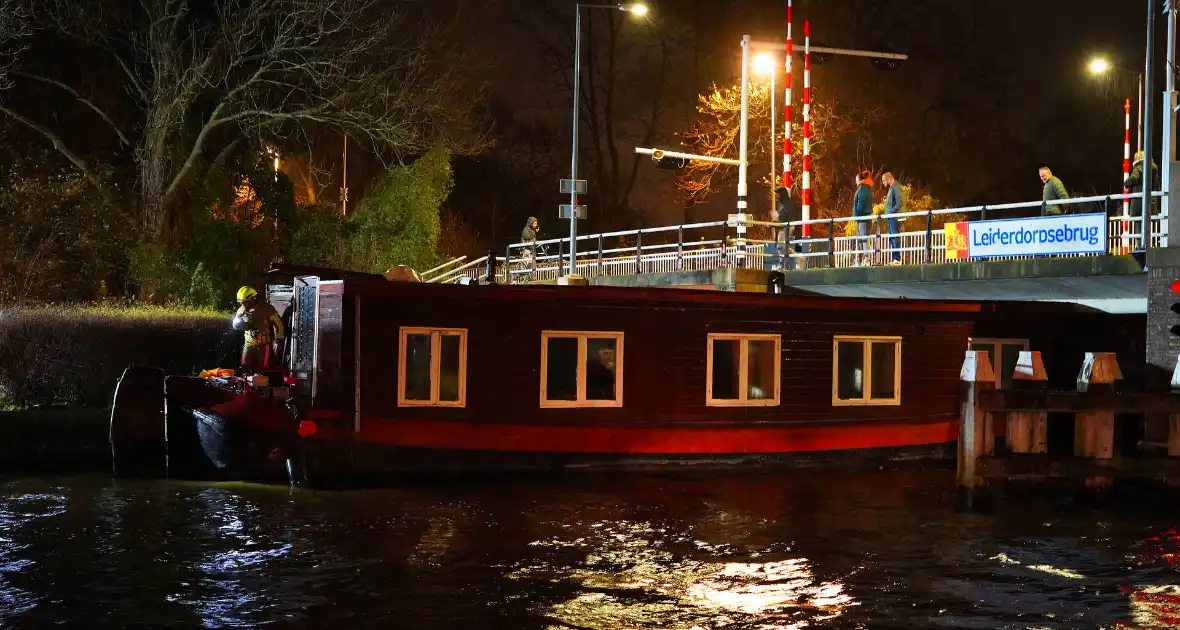 Losgeslagen woonboot komt vast te zitten onder brug