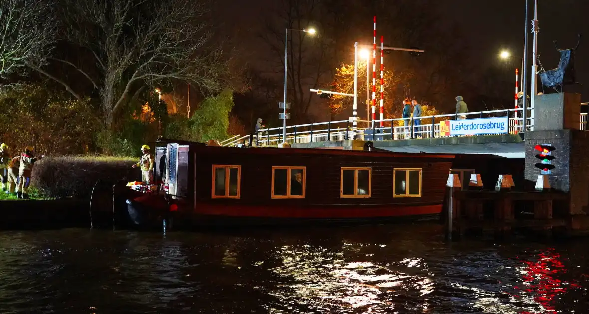 Losgeslagen woonboot komt vast te zitten onder brug - Foto 1