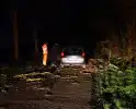 Auto komt vast te zitten tussen omgevallen bomen