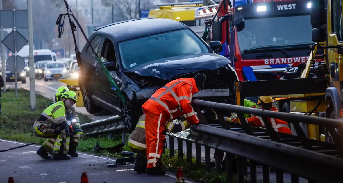 Flinke schade nadat auto op vangrail botst - Foto 1