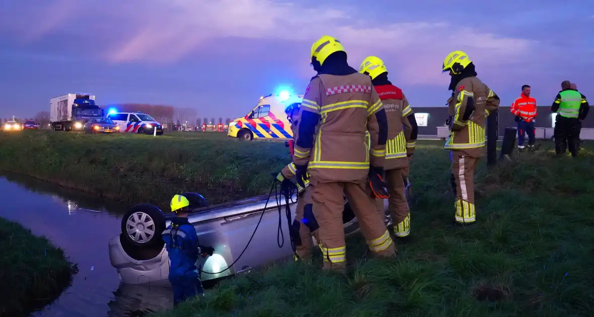 Brandweer haalt persoon uit auto in sloot