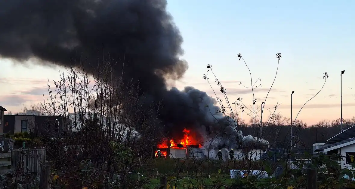 Brandweer trekt terug bij grote brand in garageboxen, instortingen door explosies