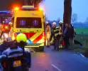 Auto op de kop na botsing met trekker en boom