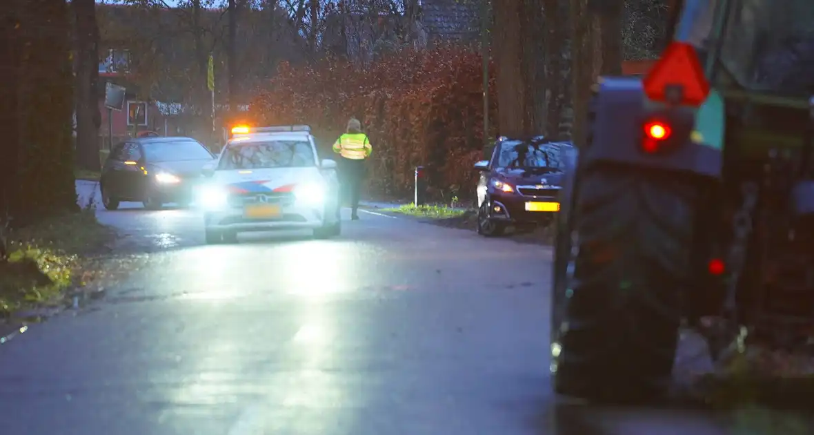 Auto op de kop na botsing met trekker en boom - Foto 1