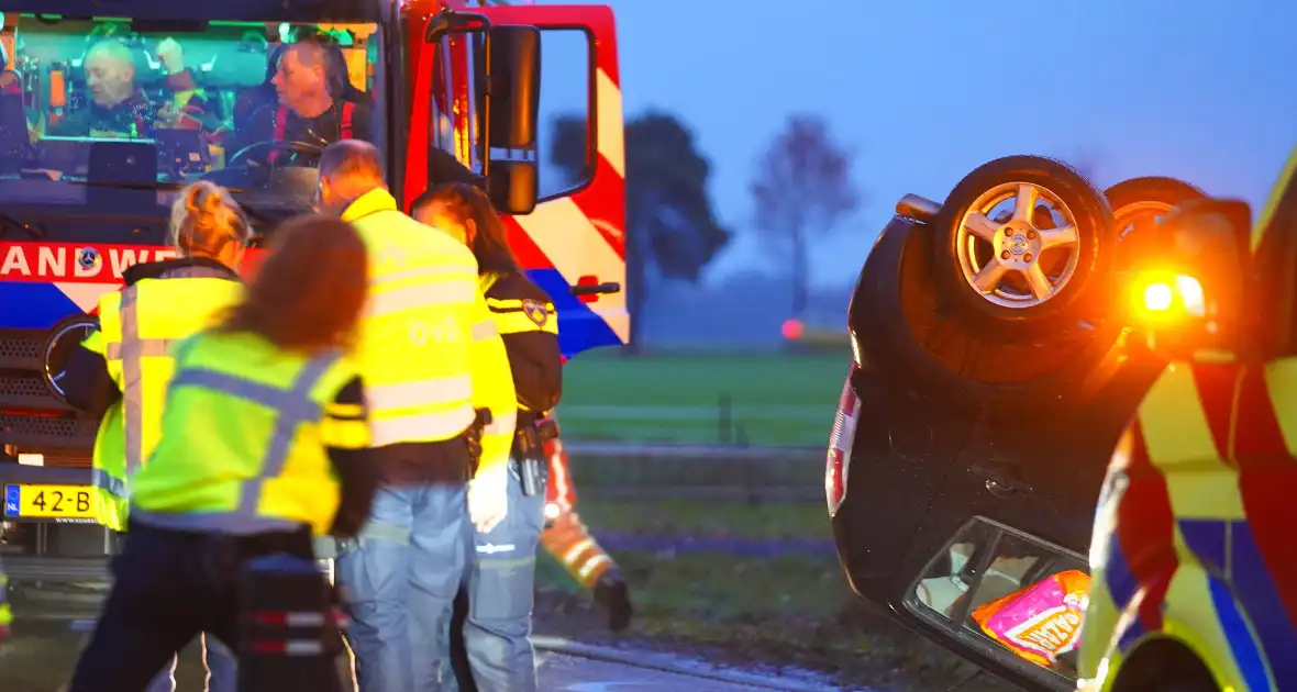 Auto op de kop na botsing met trekker en boom - Foto 3