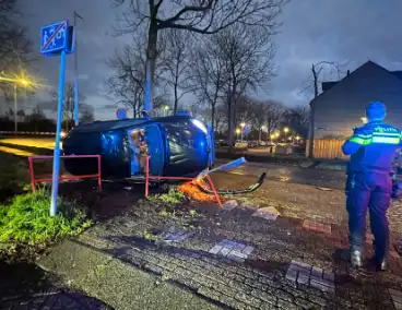 Automobilist vliegt uit de bocht belandt op zijn kant