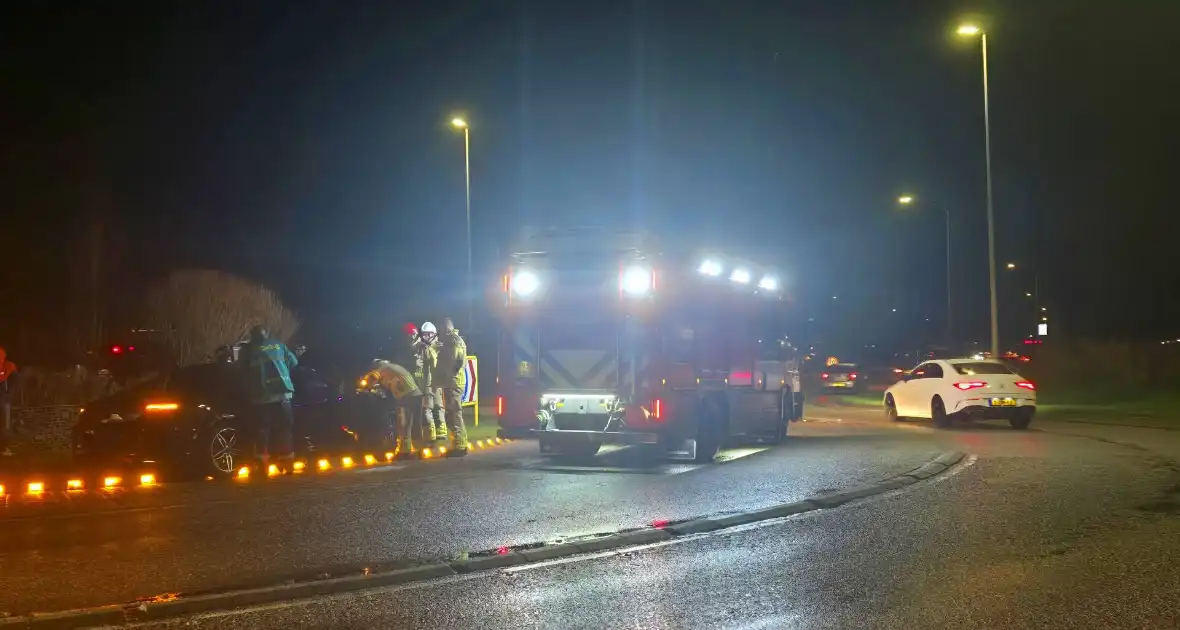 Auto belandt op midden van rotonde na botsing