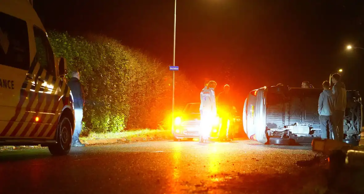 Auto botst tegen lantaarnpaal en belandt op zijkant