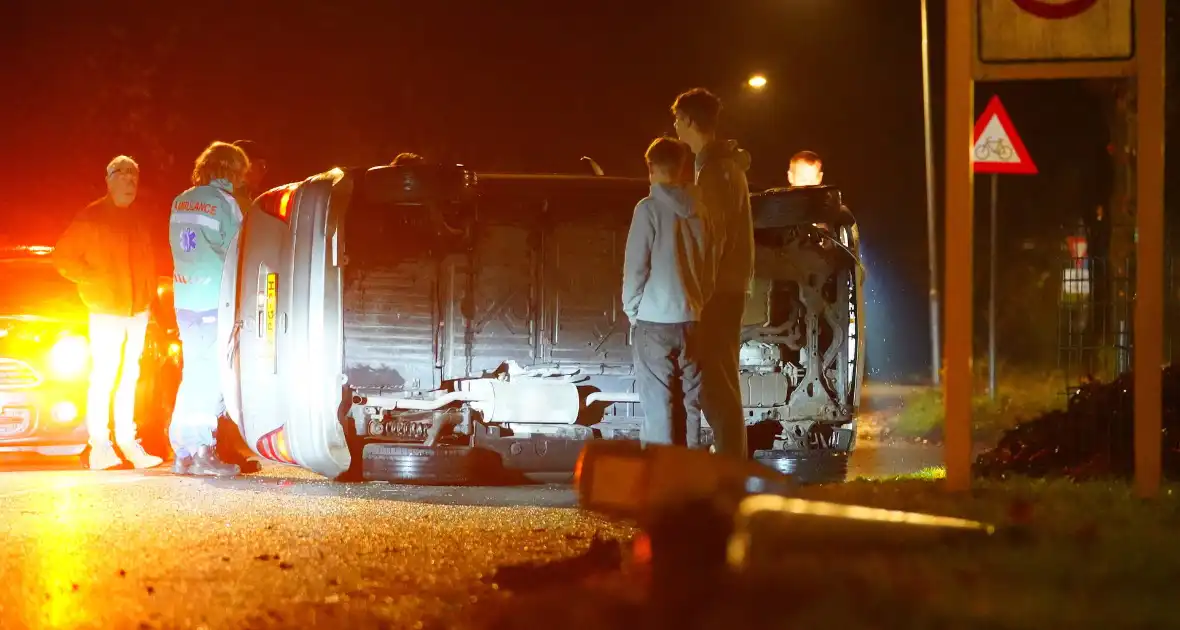 Auto botst tegen lantaarnpaal en belandt op zijkant - Foto 1