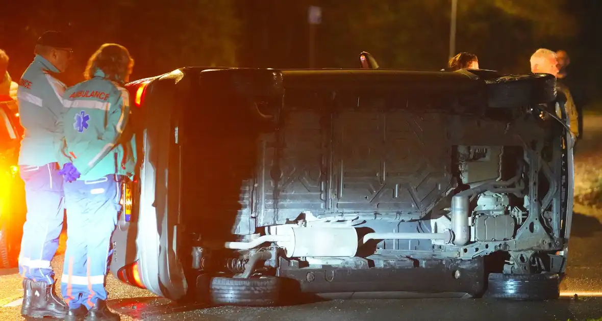 Auto botst tegen lantaarnpaal en belandt op zijkant - Foto 2