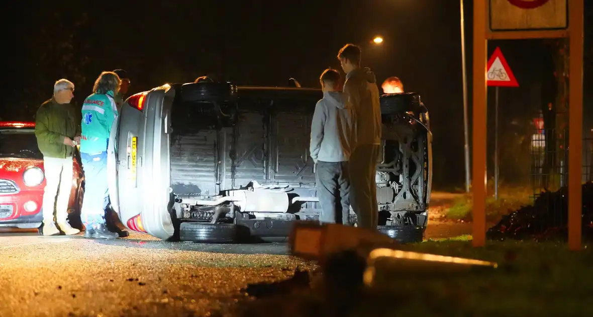 Auto botst tegen lantaarnpaal en belandt op zijkant - Foto 3