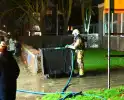 Brandweer blust brand in vuilcontainer