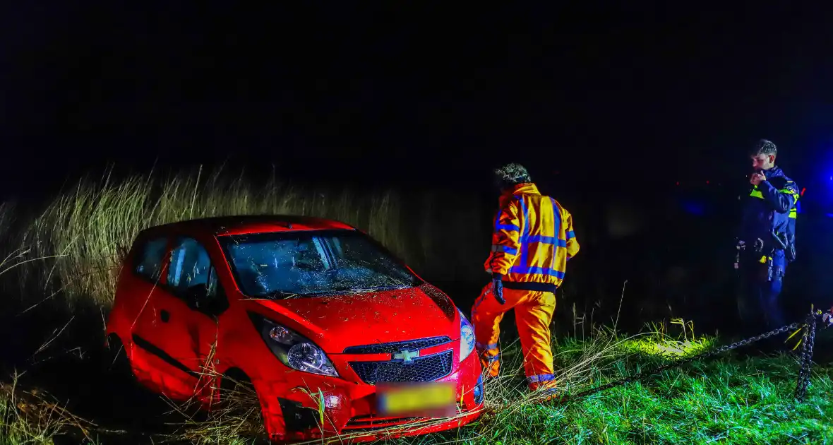 Auto belandt op zijkant langs kanaal