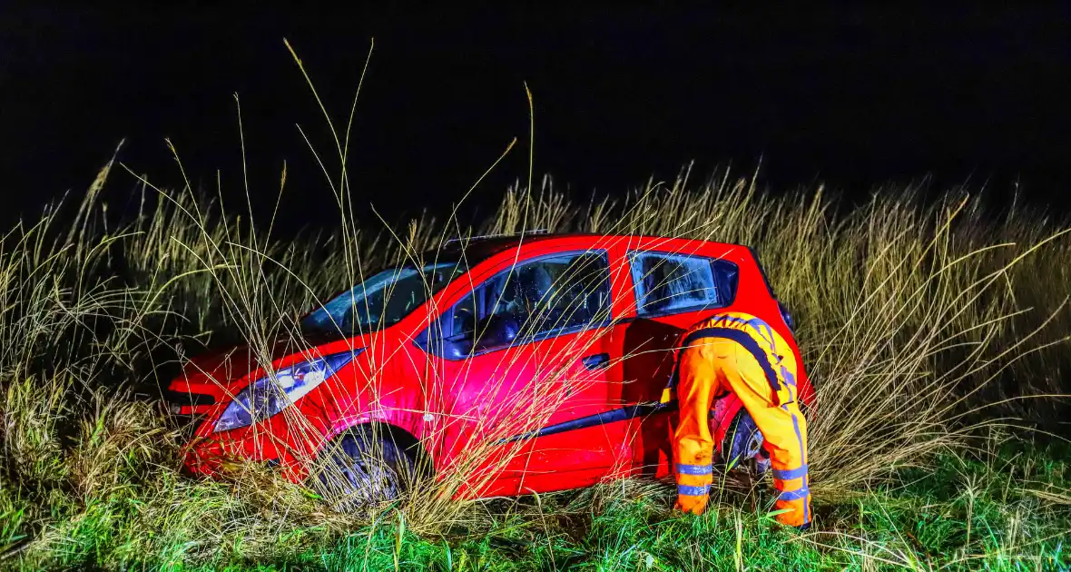 Auto belandt op zijkant langs kanaal - Foto 1