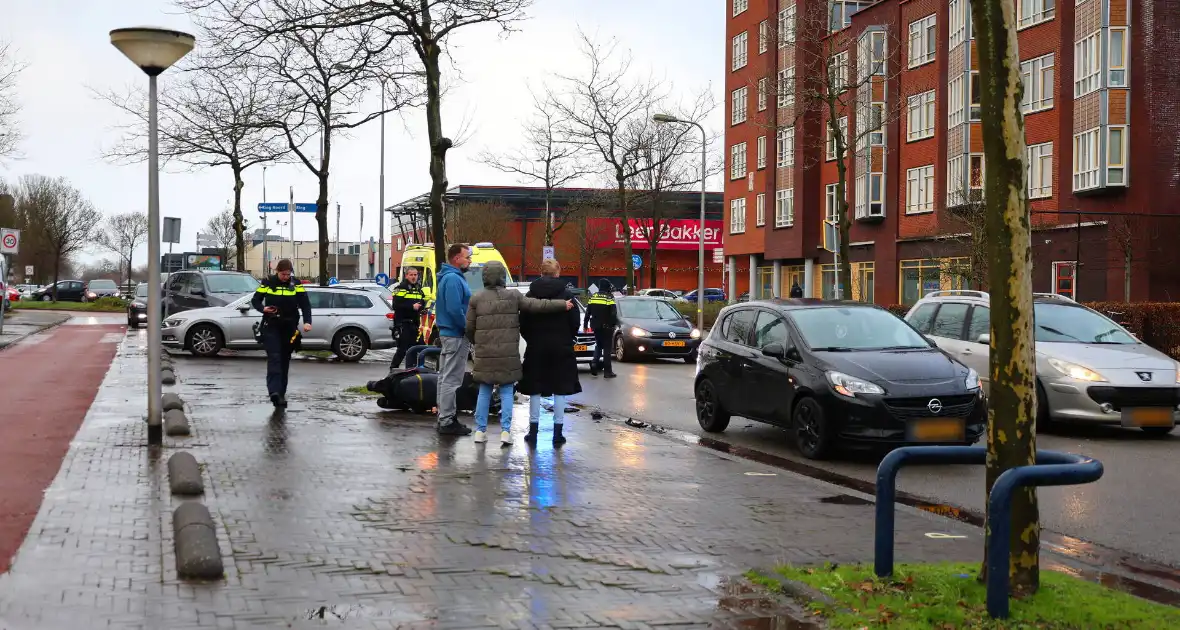 Scooterrijder klapt achterop stilstaande personenauto - Foto 1