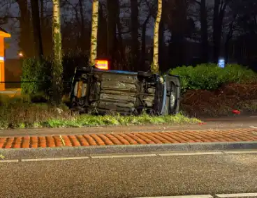 Auto vliegt uit de bocht en belandt op zijkant