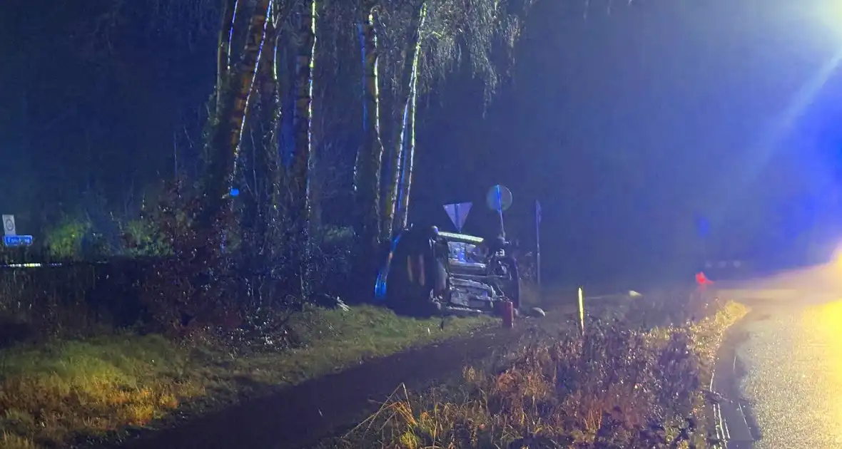 Auto vliegt uit de bocht en belandt op zijkant - Foto 2