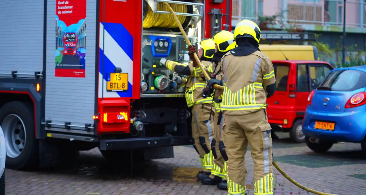 Bewoner reageert geschrokken na brand onder trap van flat - Foto 3