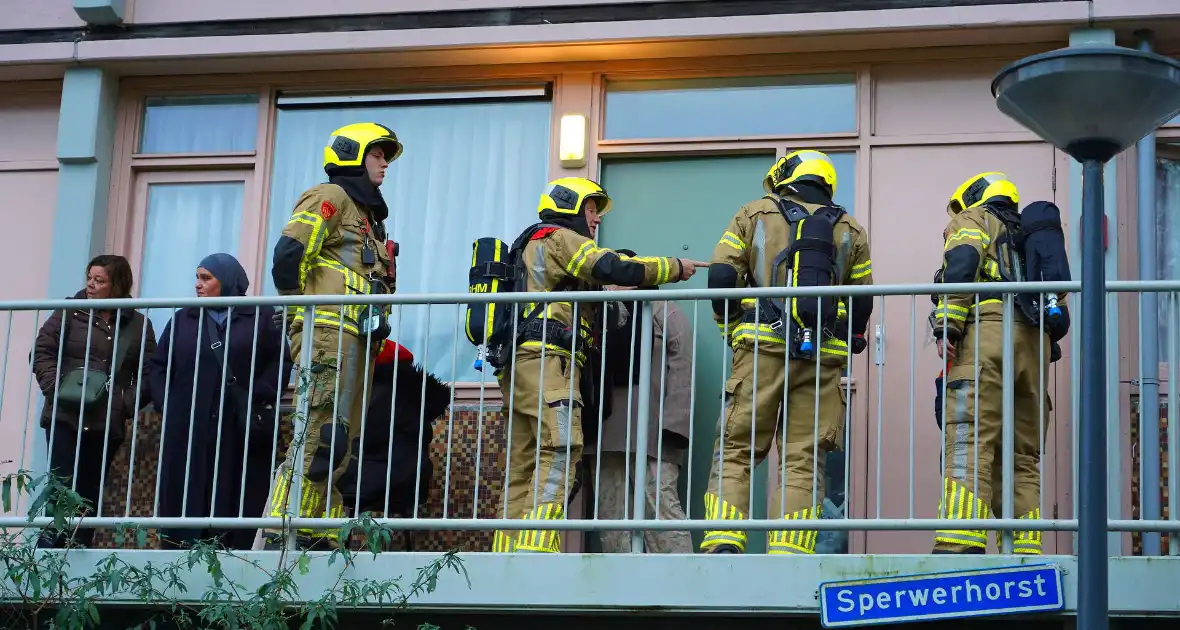 Bewoner reageert geschrokken na brand onder trap van flat - Foto 5