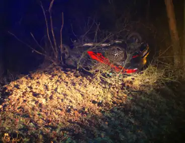 Auto vliegt uit beruchte bocht en belandt op de kop