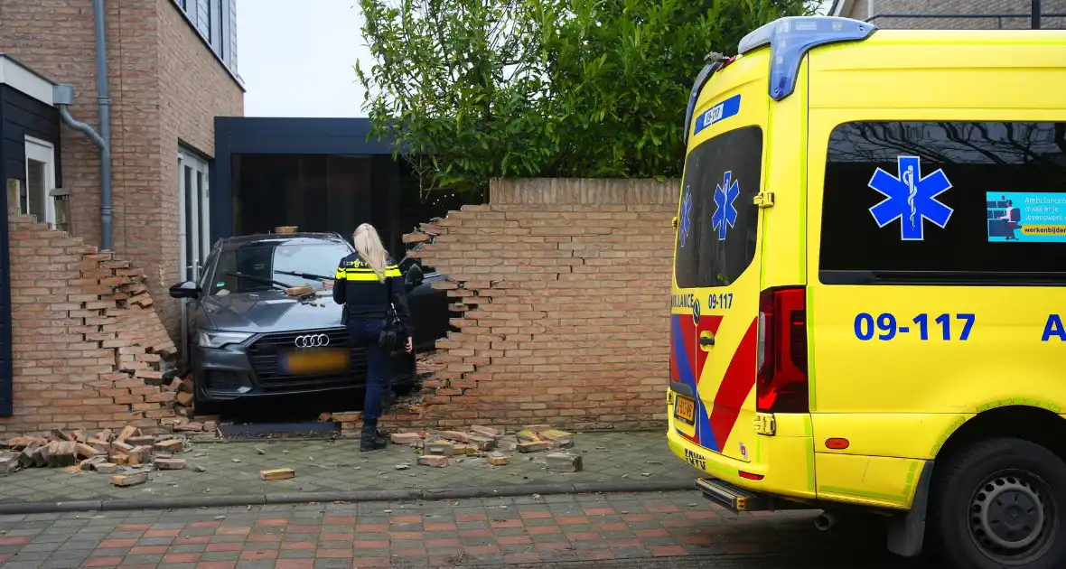 Auto rijdt dwars door tuinmuur