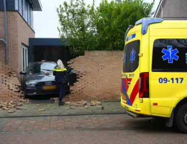 Auto rijdt dwars door tuinmuur