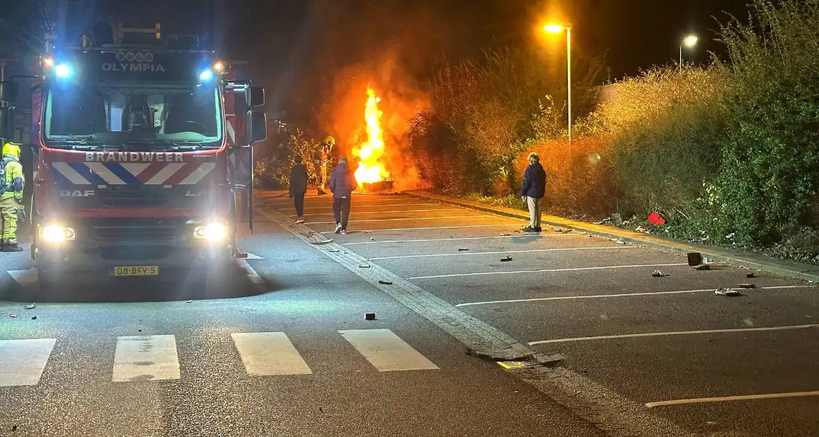 Brandweer blust afvalbrand op parkeerterrein