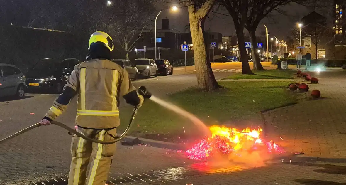 Brandweer blust afvalbrand op straat