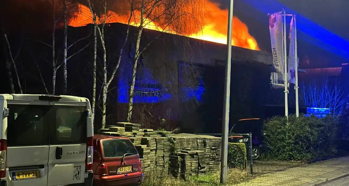 Vlammen slaan uit dak van gebouw