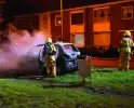 Auto in brand gestoken op grasveld