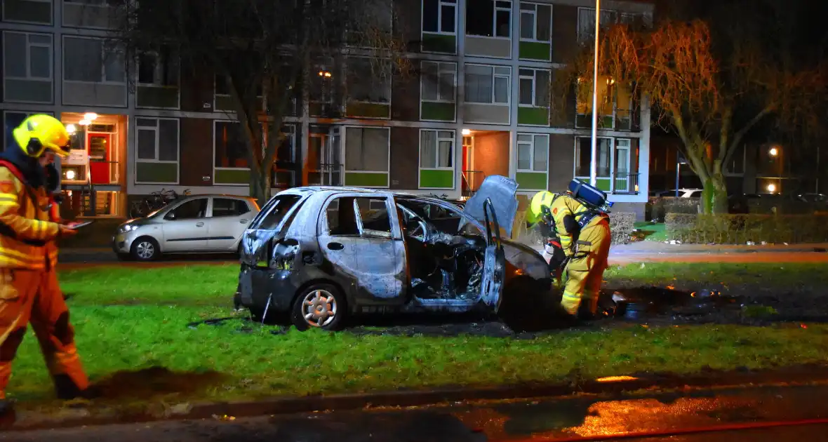 Auto in brand gestoken op grasveld - Foto 1