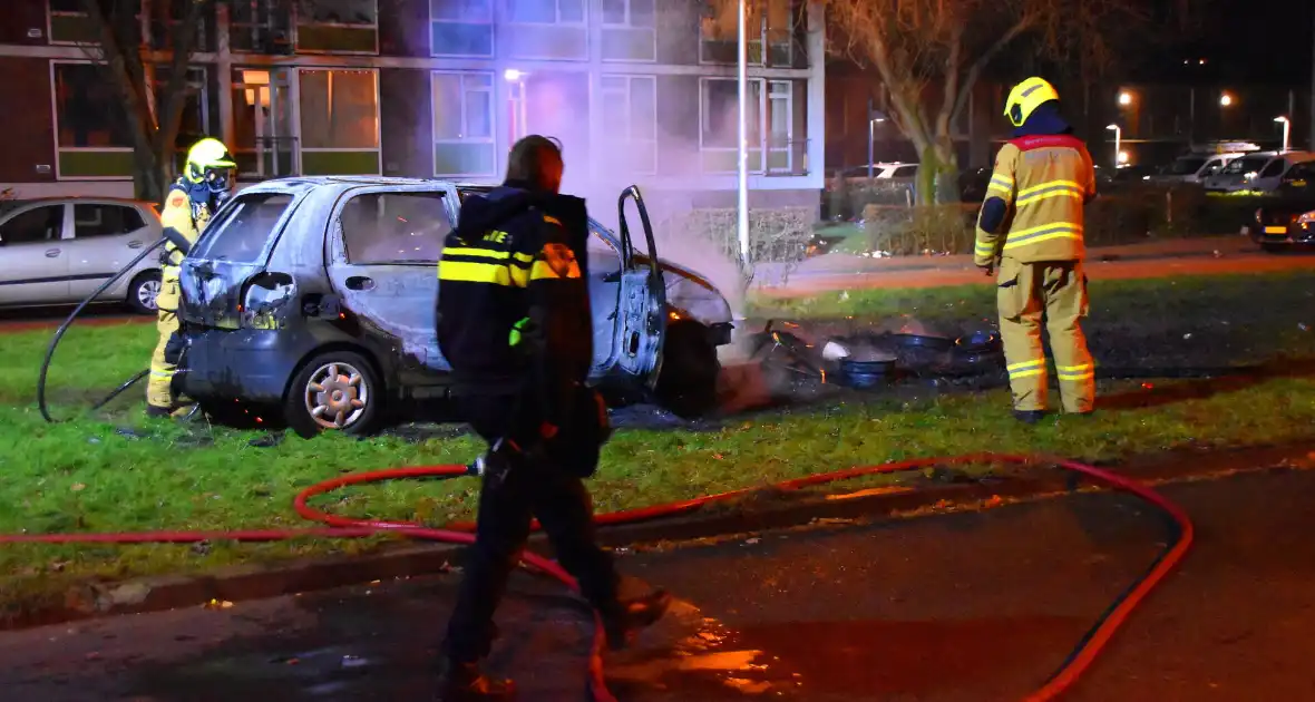 Auto in brand gestoken op grasveld - Foto 3