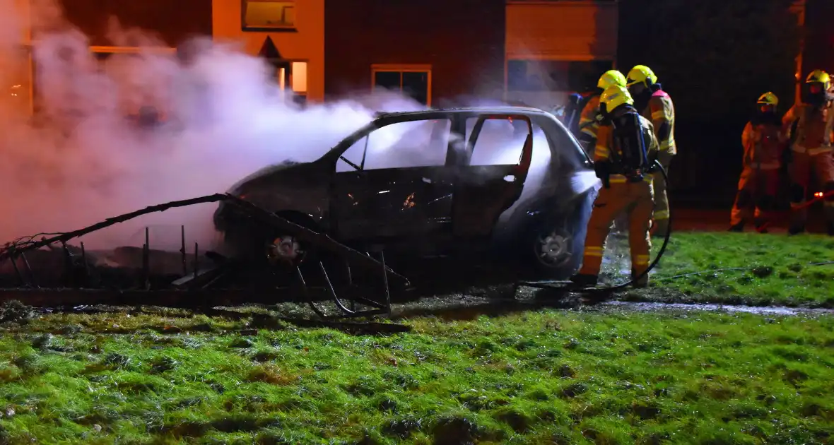 Auto in brand gestoken op grasveld - Foto 4