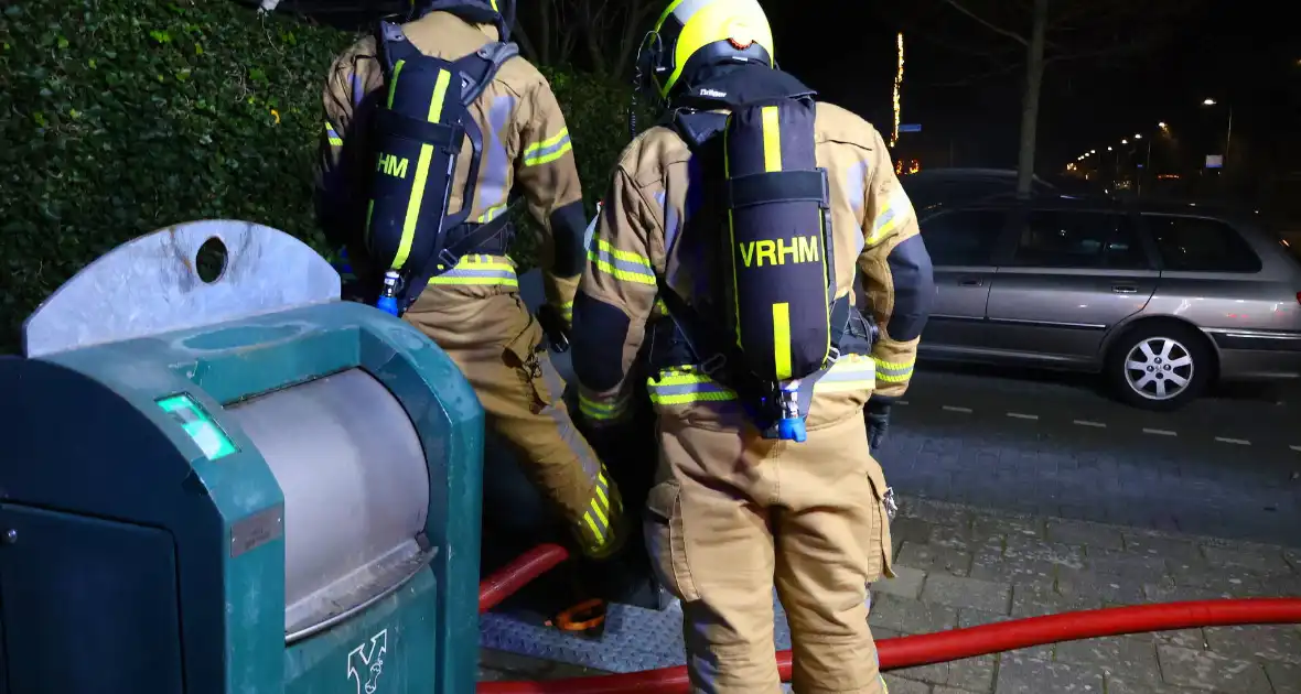 Personen verrichten bluspoging bij containerbrand - Foto 4