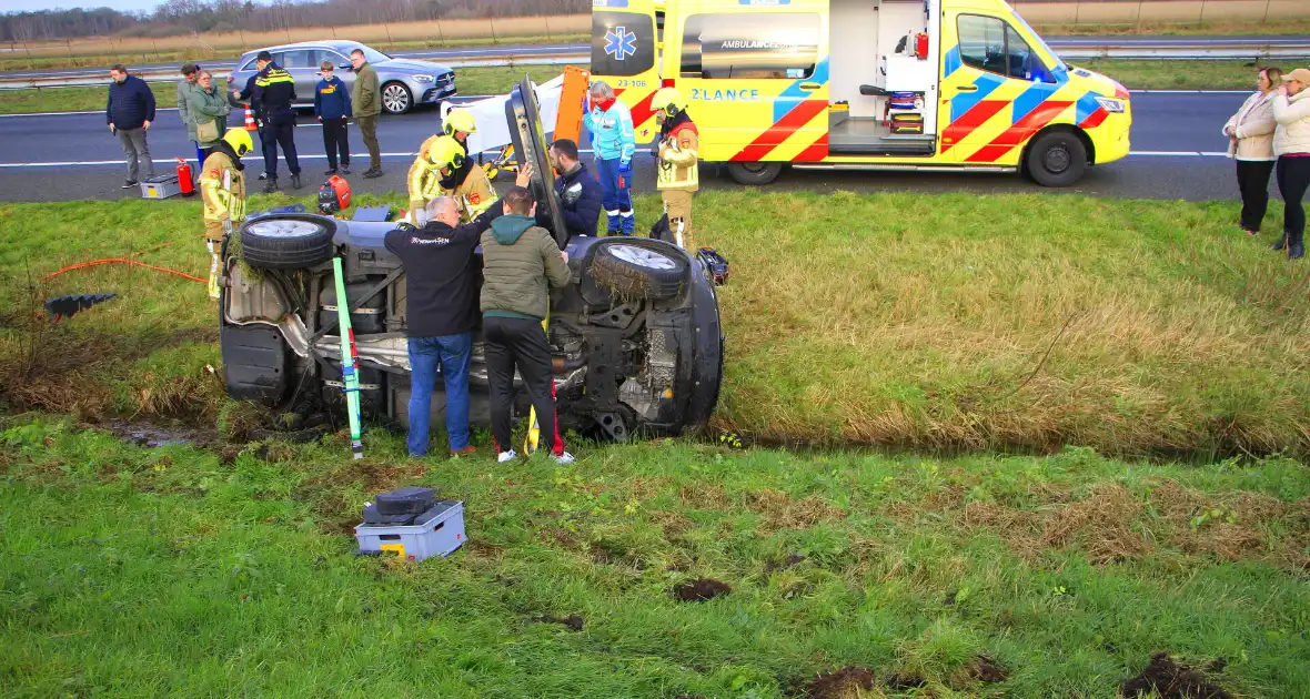 Gewonde nadat auto op zijkant in greppel naast snelweg belandt - Foto 1