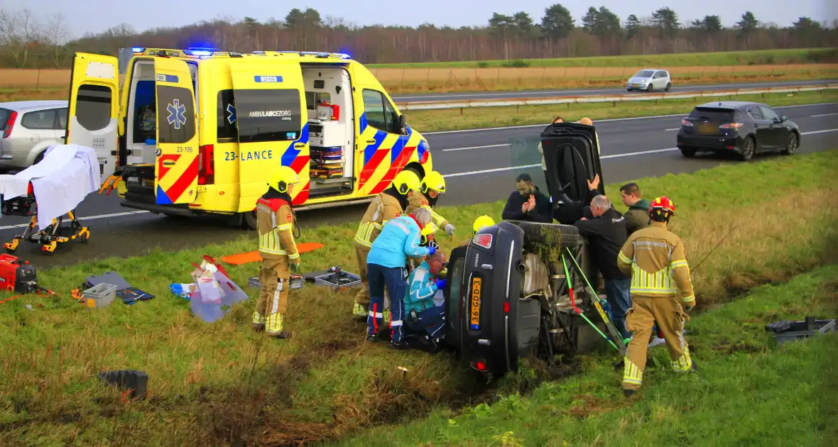 Gewonde nadat auto op zijkant in greppel naast snelweg belandt - Foto 2