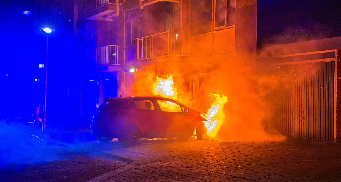 Auto brandt uit tegen gevel van flatgebouw