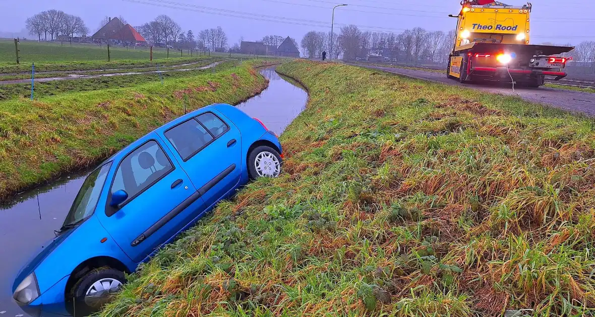 Auto te water door modderig wegdek