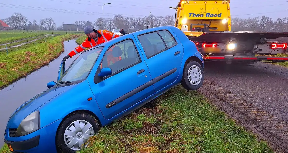 Auto te water door modderig wegdek - Foto 1