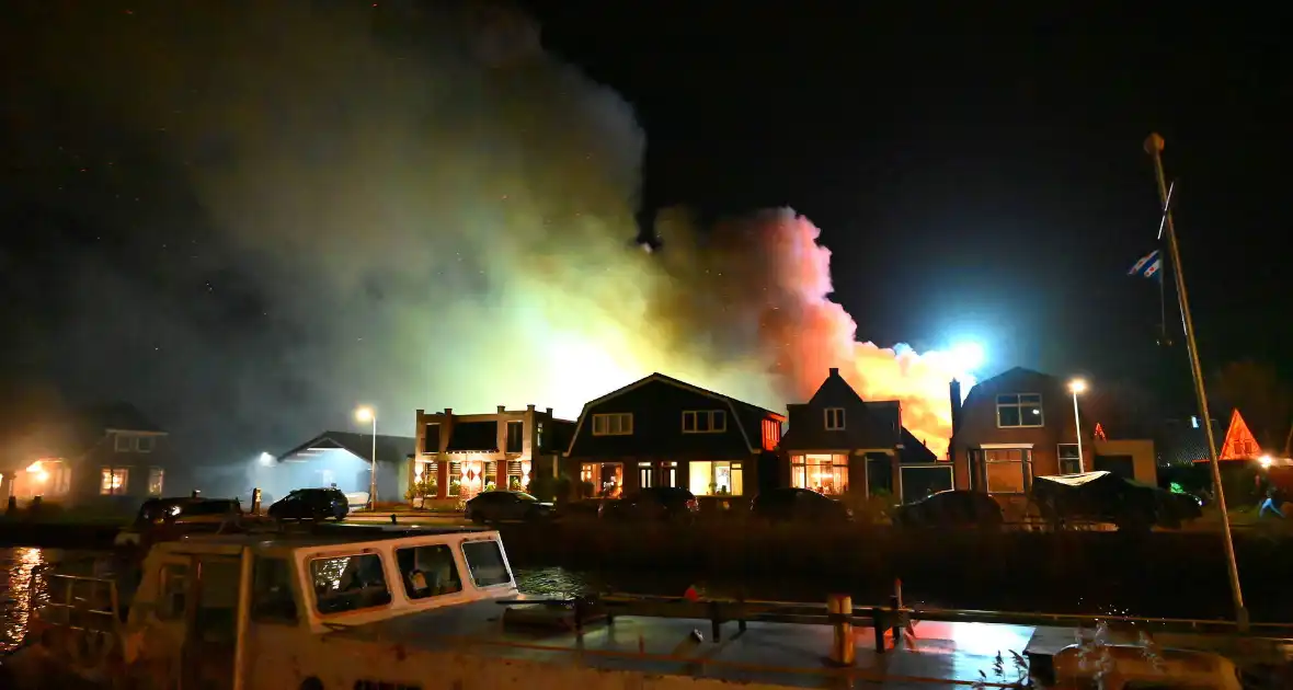 Felle uitslaande brand in loods met auto's - Foto 1