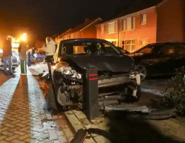 Automobilist ramt lantaarnpaal en kleine paal