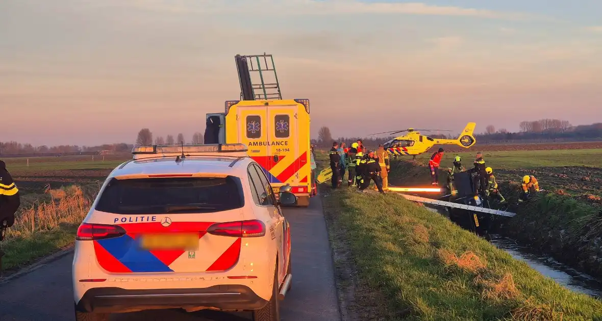 Voertuig belandt op zijkant in water na ongeval