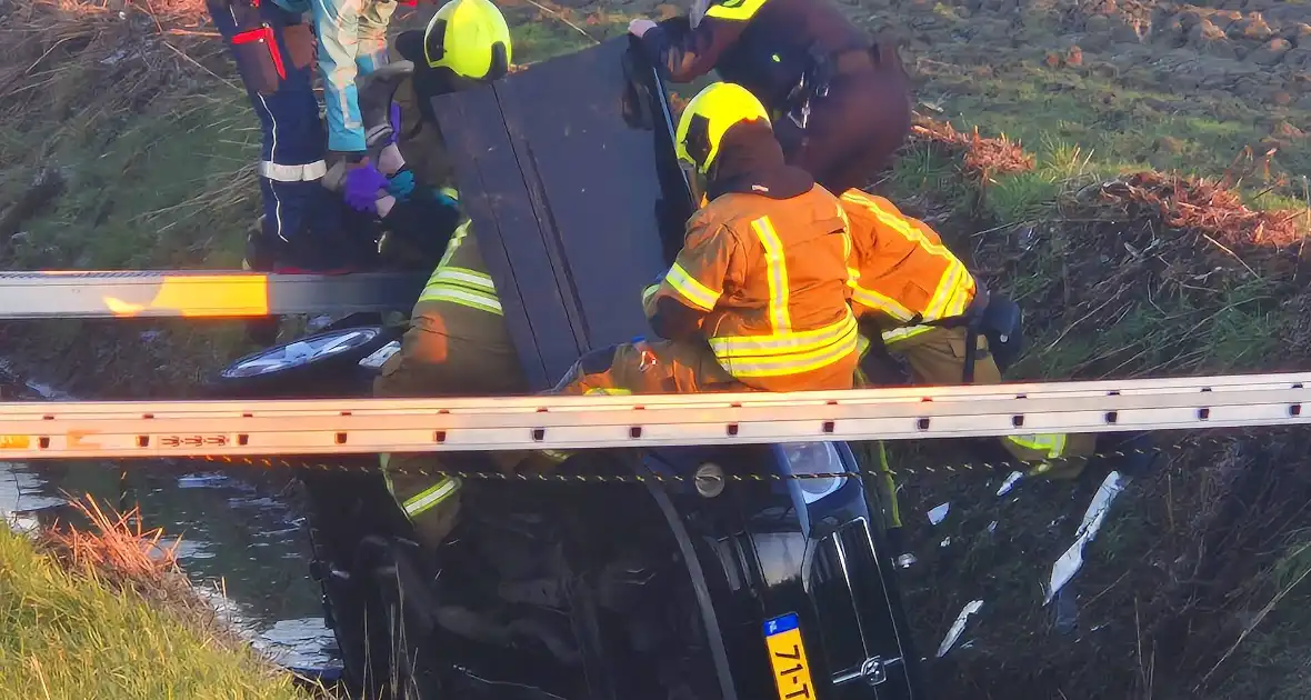 Voertuig belandt op zijkant in water na ongeval - Foto 1