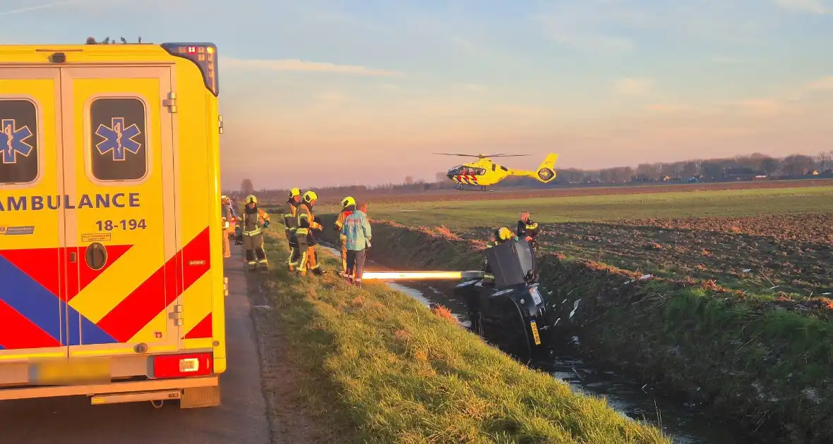 Voertuig belandt op zijkant in water na ongeval - Foto 6
