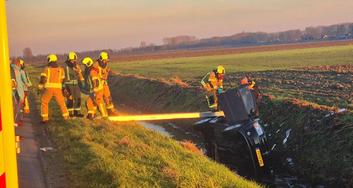 Voertuig belandt op zijkant in water na ongeval - Foto 7
