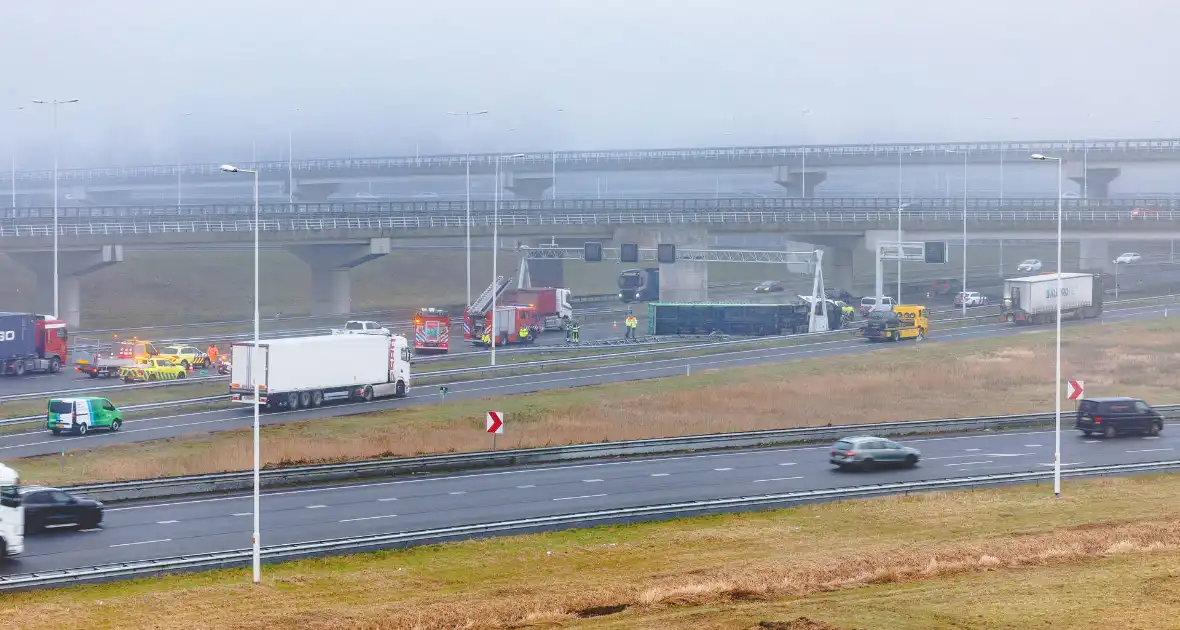 Vrachtwagen met oplegger kantelt op snelweg - Foto 1